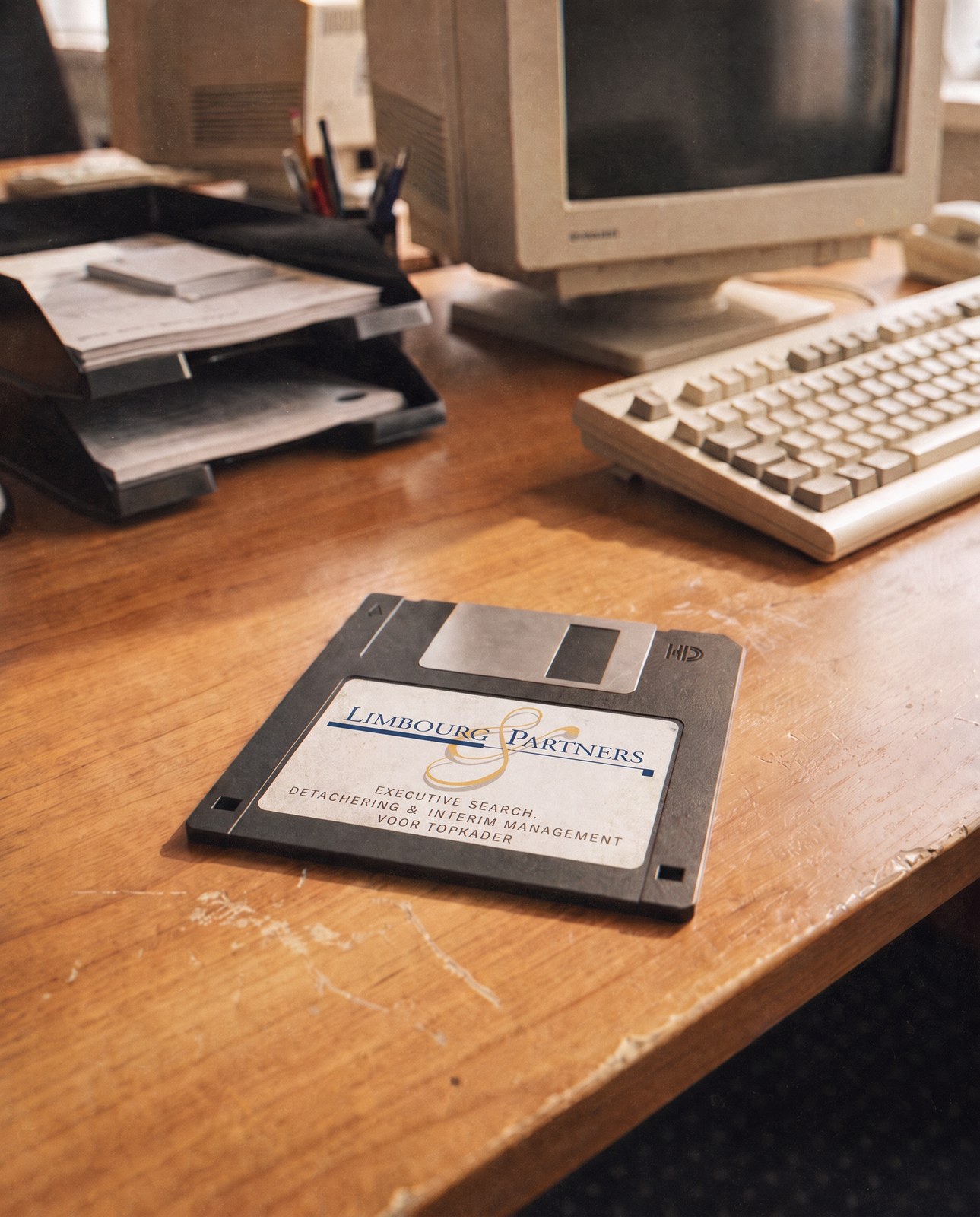 Floppy met het logo van Limbourg & Partners op een bureau uit de jaren negentig